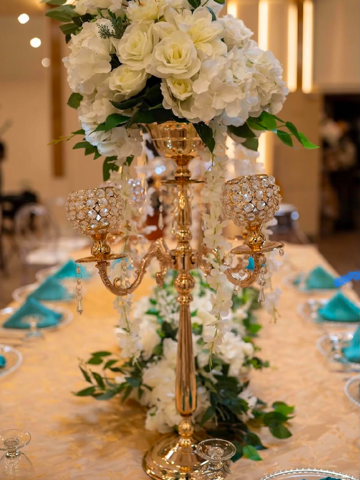 Gold candelabra centerpiece with white florals and crystals